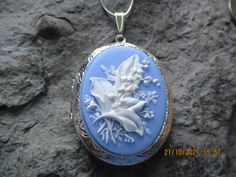 "Beautiful cameo locket. The cameo is a gorgeous lily of the valley. Stunning colors. I have this in so many colors, finishes and styles so please do browse. The bronze or silver locket is Victorian style with beautiful etching on the front and back about 2\" long, please see the photo for size. It can hold two photos or a treasured keepsake. Pass down from generation to generation. The chain is 24\" bronze link chain with a lobster claw clasp. For the silver is a 24\" silver plated snake chain. Flower Shaped Locket Jewelry For Wedding, Floral Wedding Locket Jewelry, Flower Shaped Wedding Locket Jewelry, Wedding Flower Locket Jewelry, Blue Cameo Jewelry For Wedding, Blue Cameo Necklace For Wedding, Blue Locket Jewelry For Wedding, Blue Wedding Locket Jewelry, Blue Medallion Necklace For Wedding