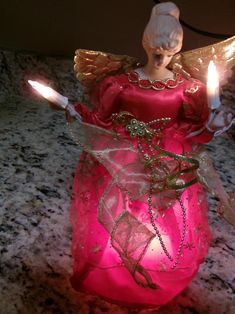 an angel figurine with two candles in its hands