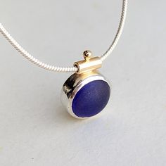 This captivating deep cobalt blue sea glass necklace from Booblinka Jewellery’s Allure Collection is a one-of-a-kind treasure that reflects the mesmerizing depths of the Cornish coast. Hand-shaped and set in a harmonious mix of sterling silver and 9 carat gold, the stunning sea glass pendant showcases the timeless allure of the ocean. The cobalt blue sea glass, approximately 10mm in diameter and 15mm in height, mirrors the vibrant hues and textures of the Atlantic waves. Suspended from an 18-inc Sea Glass Mirror, Blue Sea Glass Necklace, Cornish Coast, Sea Glass Pendant, Blue Sea Glass, Blue Pendant, Sea Glass Necklace, The Atlantic, Recycled Sterling Silver