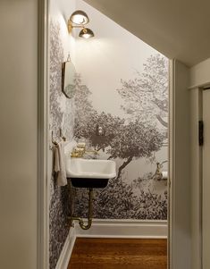 a bathroom with a sink, mirror and wallpaper on the walls in it's corner