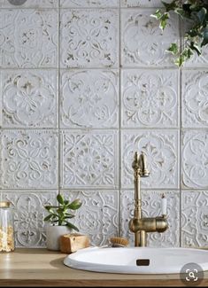 a white sink sitting under a faucet next to a wooden counter