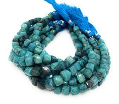 three strands of turquoise beads with blue tassels