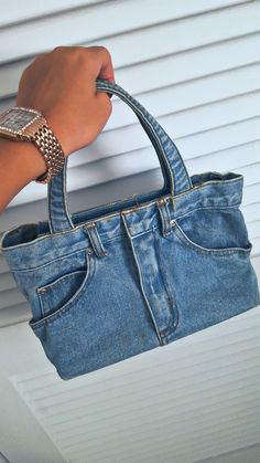 a woman's hand holding onto a blue purse