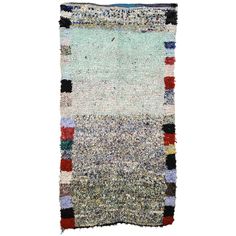 an old rug with multicolored squares and fringes on the bottom, against a white background