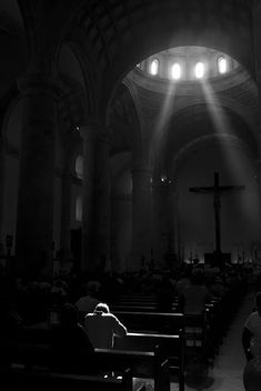 people sitting in pews with the light streaming through them and shining down on them