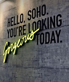 a neon sign on the side of a building that says, hello, soho you're looking gorgeous today