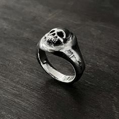 This skull ring is perfect for the macabre person in your life. This solid oxidised 925 sterling silver signet ring features a melted skull design. Solid oxidised 925 sterling silver signet ring featuring a melted skull design. Top of ring measures 1.3cm x 1.3cm 925 Oxidised Sterling Silver Each piece is handmade to order in the Jewel Thief Brighton atelier. Gothic Skull Rings With Engraving, Symbolic Skull Rings For Halloween, Halloween Skull Rings Symbolic Style, Halloween Engraved Skull Ring Gift, Halloween Skull Print Rings For Gift, Halloween Skull Print Rings As Gift, Hand Cast Black Skull Ring, Black Hand Cast Skull Ring Gift, Halloween Skull Promise Ring