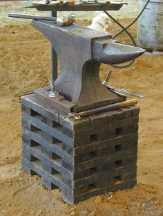 a hammer and an old brick block on the ground with a horse in the background