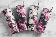 three tumbles with pink roses and butterflies on them sitting on a marble counter top