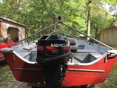 a red and black boat parked in the grass