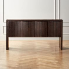 a wooden bench sitting on top of a hard wood floor next to a white wall