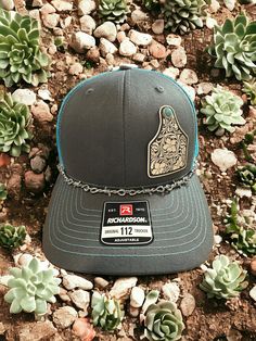 Welcome to DMDesignsPlus Etsy store! We sell a variety of handmade and personalized items perfect for holiday gifts, party stuffers, and more!  Product Information: Richardson 112 SnapBack Hat with Charcoal Grey/Teal Coloring, White tooled vegan leather patch with faux turquoise accents, Western Hat Richardson 112 SnapBack Hat---Charcoal Grey/Teal. White tooled vegan leather patch with faux turquoise accents.  Includes barbed wire removable hat chain.  Thank you for shopping small! Please remember to leave a review. It helps us a lot! Teal Country Hat, Western Accessories Hats Women, Western White Baseball Hat, Kimes Ranch Hat Teal, Western Accessories Hats, Laser Leather Hats, Hand Tooled Leather Hat, Leather Hat Patch Ideas, Western Trucker Hats