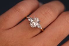 a woman's hand with a diamond ring on top of her finger and an engagement band