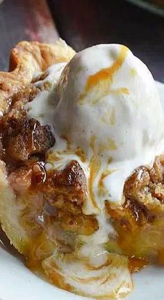 a piece of pie with ice cream on top is sitting on a white plate and ready to be eaten