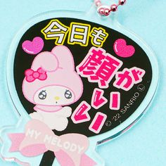 a keychain with an image of a hello kitty doll on it's side