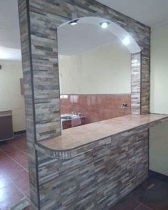 a bathroom with a stone counter top and mirror on the wall, next to a tiled floor