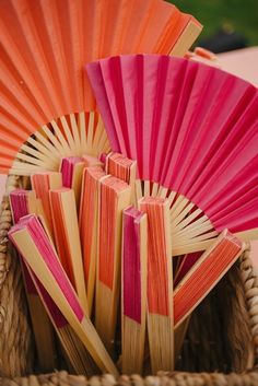 an orange and pink fan sitting in a basket