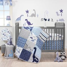 a baby crib with blue and gray dinosaur wall decals