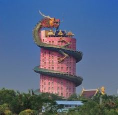 a tall pink tower with two dragon statues on top