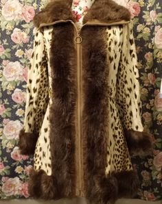 This coat is wildly fantastic in so many ways and will be a huge hit casual or dressed up. It has so much paxzaz going on from the fun animal print to the thick faux fur trim, gold button details, 70s collar and bell sleeves. Size small/medium Measurements: 34' long Shoulder to shoulder 16' Arms 22' Bell sleeves 8' Waist 15.5' Pit to pit 18' Light to Medium weight Made in Scotland Furrier cleaning recommended Fitted Faux Fur Outerwear In Leopard Print, Fitted Leopard Print Faux Fur Outerwear, Fitted Leopard Print Winter Outerwear, Retro Fitted Fur Coat With Faux Fur Trim, Fitted Leopard Print Fur Coat For Fall, Fitted Retro Fur Coat For Fall, Vintage Leopard Print Winter Outerwear, Vintage Leopard Print Outerwear For Winter, Brown Fitted Long Fur Coat