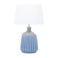 a blue and white ceramic lamp with a white shade on the top, against a white background