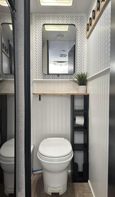 a white toilet sitting in a bathroom next to a shelf filled with towels and other items