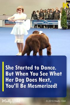 a woman standing next to a brown bear on top of a blue carpeted floor