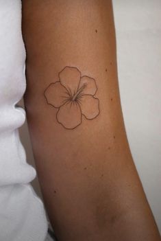 a small flower tattoo on the arm