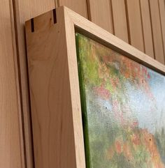 a close up of a wooden frame on a wall with flowers painted on the wood