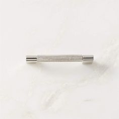 a white marble surface with a metal bar on it's end and the tip of an object in the middle