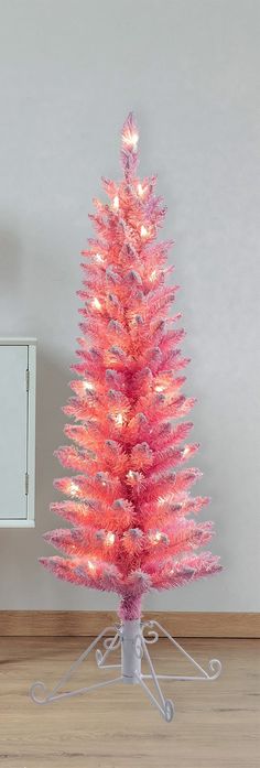 a pink christmas tree with white lights on it