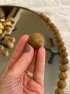 a hand holding a rock in front of a mirror