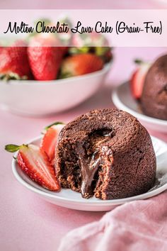 a chocolate cake is cut in half on a plate with strawberries next to it