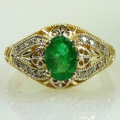 ALL OUR JEWELRY IS HANDCRAFTED IN THE USA ALL OUR GEMSTONES ARE NATURAL NOT LAB CREATED Such a lovely, delicate filigree Emerald ring, and encrusted with 16 Diamonds. This genuine Colombian Emerald is of exceptional color and clarity is just beautiful. The beading and filigree in the gold mounting encircle nearly the entire ring!  It would make an exquisite engagement or May birthstone ring!  Set in solid 14k yellow gold.  You will absolutely ADORE this ring!! One 8x6 oval Emerald, 1.50 carats S Fine Jewelry Emerald Ring With Intricate Design, Oval Filigree Ring With 17 Jewels For Anniversary, Fine Jewelry Yellow Gold Emerald Ring With Intricate Design, Gold Emerald Ring With Intricate Design, Oval Shape, Oval Gold Emerald Ring With Intricate Design, Ornate 14k Filigree Ring For Anniversary, Ornate Filigree Ring Stamped 14k For Anniversary, Elegant Yellow Gold Emerald Ring With Intricate Design, Elegant Round Emerald Filigree Ring