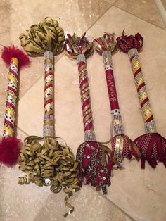 four different types of ribbons and bows on the floor next to each other with red pom - poms