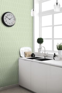 a kitchen with a clock on the wall next to a sink and counter top in front of a window