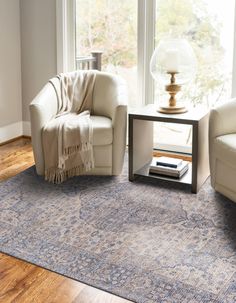 a living room with two chairs and a rug