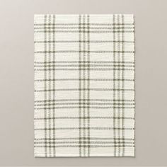 a white and green checkered cloth hanging on a wall in front of a gray background