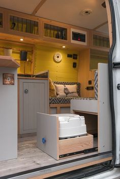 the interior of a camper van with its door open and storage drawers in place