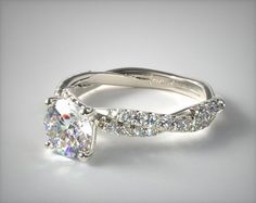 a white gold engagement ring with a cushion cut diamond