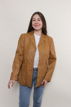 Step out in style with this vintage 90s leather jacket! Crafted from high-quality leather in a rich brown color, this jacket features a button-up closure for a classic look. Please note that this is a vintage item, so it may have some defects. Additional photos are available upon request. For accurate sizing, refer to the following measurements taken seam to seam while lying flat: Sleeve: 43 cm / 16.92 inches Width: 44 cm / 17.32 inches Length: 71 cm / 27.95 inches Add this stylish jacket to you Brown Leather Outerwear With Notch Lapel, Fitted Brown Leather Button-up Jacket, Fitted Brown Leather Jacket With Buttons, Brown Leather Button-up Blazer, Brown Button-up Leather Jacket For Fall, Brown Leather Jacket With Button Closure For Work, Brown Leather Jacket With Button Closure For Fall, Brown Leather Jacket With Buttons For Fall, Winter Brown Blazer With Snap Buttons