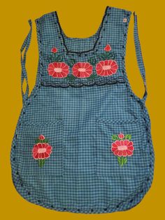 a blue apron with red flowers on it