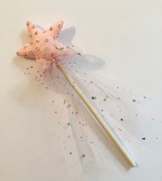 a pink star wand with stars on it sitting next to a white wall and floor