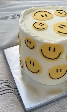 a cake with smiley faces on it sitting on top of a table next to a napkin