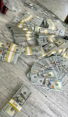 a pile of money sitting on top of a counter next to a pair of red shoes