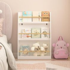 a child's bedroom with pink walls and white furniture, including a bookcase filled with children's books