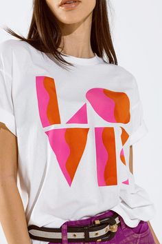 Introducing our T-Shirt with a captivating Love Art Deco Digital Print in bright pink and orange colors, adding a vibrant touch to your everyday wardrobe. This white tee is not just a piece of clothing; it's an expression of style and positivity.  Made in Italy with meticulous craftsmanship, this t-shirt features a classic crew neckline and short sleeves, providing comfort for daily wear. The standard fit ensures a relaxed and easy-going silhouette, perfect for the spring and summer seasons.  The LOVE digital print on the front adds a playful and artistic element to the tee, making it a standout piece in your collection. Crafted from 100% cotton, this shirt offers both softness and breathability, enhancing the overall wearing experience.  The model in the image is wearing size U, with body T Shirt Branca, Printed Tshirt, Easy Going, Laid Back Style, White Tee, Graphic Tee Shirts, Everyday Wardrobe, Summer Wear, White Tshirt