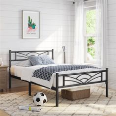 a bedroom with a soccer ball on the floor and a window in the wall behind it