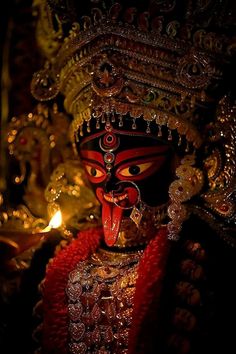 a close up of a statue with a lit candle in the background