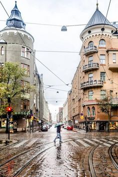 a person with an umbrella is walking down the street in the rain on a rainy day